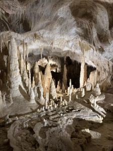 Tropfsteinhöhle mit zahlreichen Stalaktiten und Stalagmiten im Inneren.