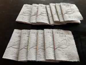 Mehrere handgefertigte Notizhefte aus Papier liegen auf einem Tisch.