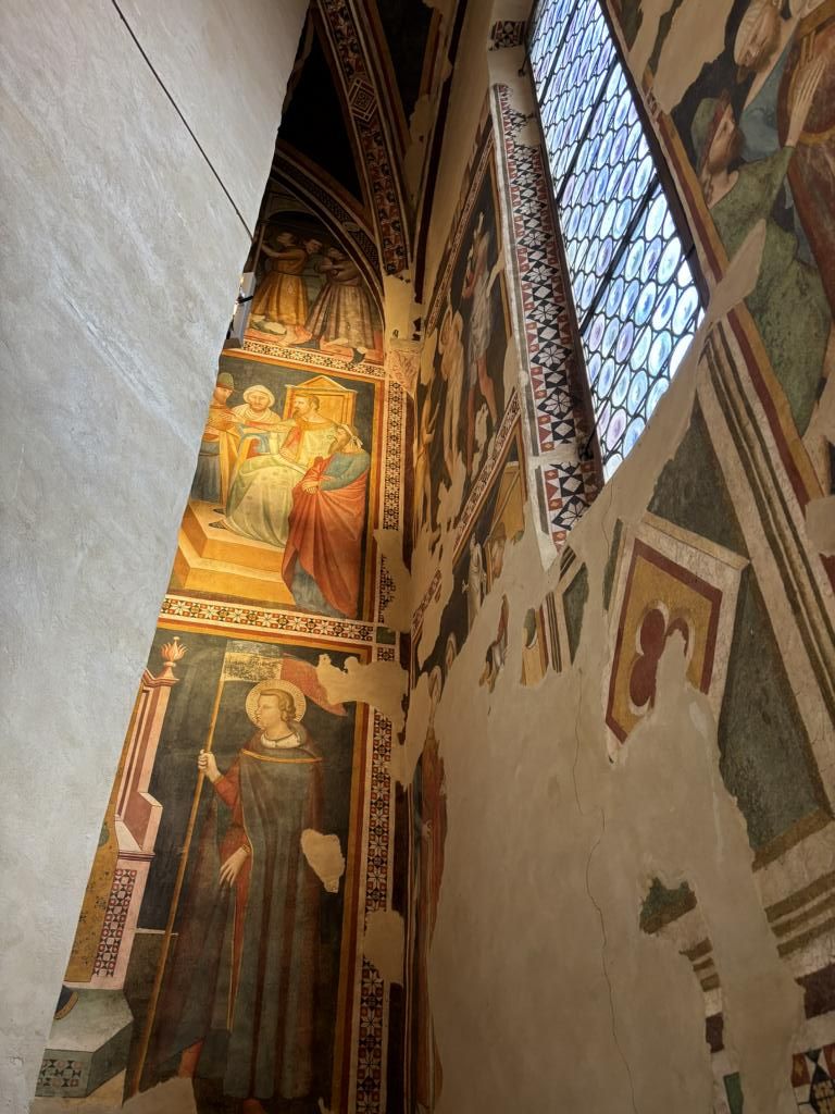 Das Bild zeigt kunstvolle Fresken an Wänden und Decke einer Kirche in Fabriano, die religiöse Motive und Figuren aus vergangenen Jahrhunderten darstellen.