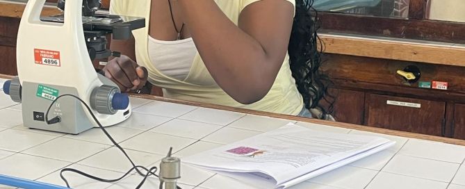 Eine Schülerin untersucht eine Probe mit einem Mikroskop im naturwissenschaftlichen Labor der italienischen Partnerschule in Fabriano. Auf dem Labortisch befinden sich verschiedene Gasanschlüsse und Unterrichtsmaterialien.
